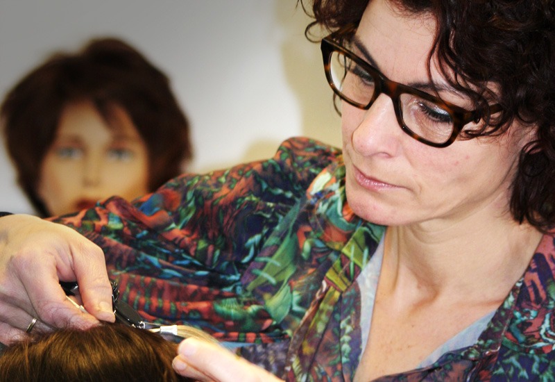 Tarita werkt aan een haarwerk op een hoofdmodel