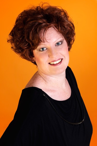 Portret van een vrouw met een kort, roodbruin haarwerk